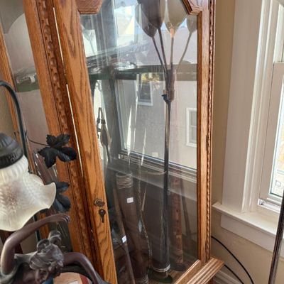Sale Photo Thumbnail #250: Traditional oak display cabinet featuring glass doors, interior shelving, and carved accent details.