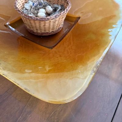 Sale Photo Thumbnail #285: Large amber art glass display bowl featuring a small decorative woven basket with a faux bird nest and eggs in the center.