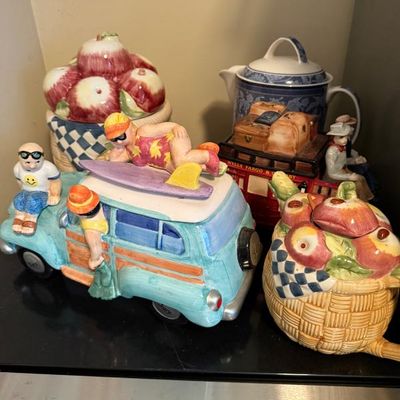 Sale Photo Thumbnail #362: Collection of decorative ceramic teapots and cookie jars, featuring a surf wagon theme, fruit baskets, and a Wells Fargo stagecoach.