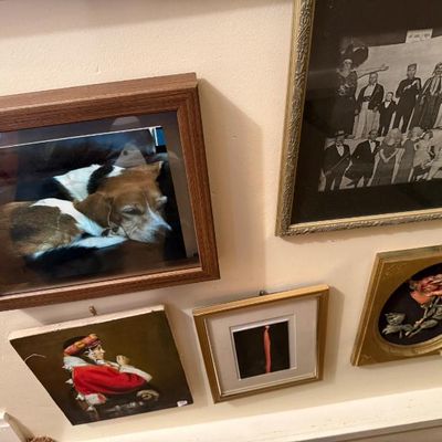 Sale Photo Thumbnail #126: A gallery wall arrangement of assorted framed artwork and photographs, including a dog photo, vintage group portrait, and a 3D floral art piece in a gold frame.