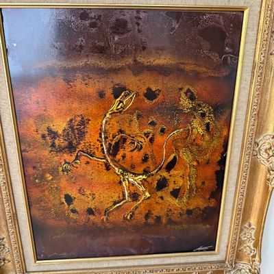 Sale Photo Thumbnail #87: Framed mid-century copper enamel artwork depicting a dinosaur skeleton against a textured background. Housed in a ornate gilt frame with a fabric mat liner.