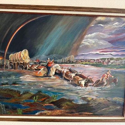 Sale Photo Thumbnail #83: Framed Western oil painting on canvas depicting a cattle drive and covered wagons crossing a river under a stormy rainbow sky, signed by the artist in the lower right.