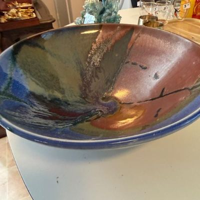 Sale Photo Thumbnail #311: Large studio pottery bowl featuring a multi-colored glazed abstract pattern in shades of blue, green, and terracotta.