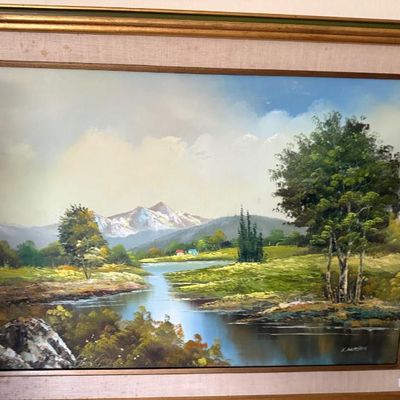 Sale Photo Thumbnail #76: Framed oil painting depicting a scenic landscape with a winding river, trees, and snow-capped mountains in the background, signed by the artist in the lower right corner.