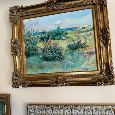 Sale Photo Thumbnail #95: Impressionist-style oil painting of a coastal landscape with flowering bushes, presented in an ornate gilt wood frame.
