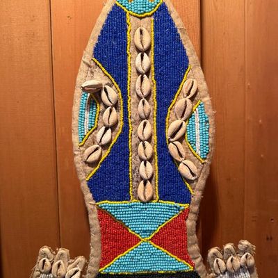 Sale Photo Thumbnail #204: Handcrafted African beaded wall hanging embellished with cowrie shells and vibrant multi-colored seed beads on a burlap backing.