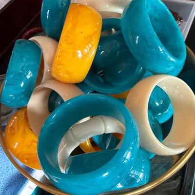 Sale Photo Thumbnail #34: Collection of vintage chunky Lucite or Bakelite-style bangle bracelets in vibrant turquoise, marbled yellow, and cream shades.