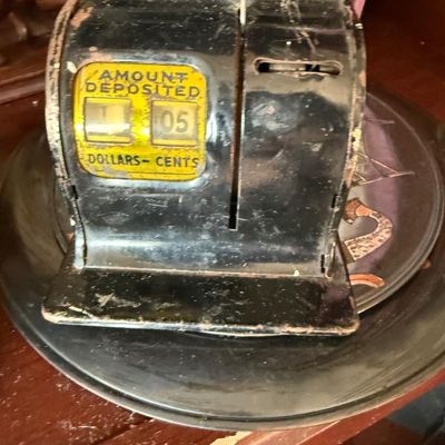 Sale Photo Thumbnail #243: Vintage black tin litho toy cash register bank featuring a yellow 'Amount Deposited' display dial, showing wear and light patina.