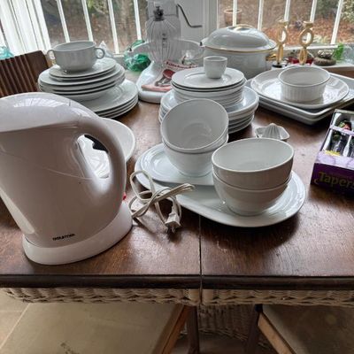 Sale Photo Thumbnail #315: A collection of white kitchen items including a KitchenAid stand mixer, a Gourmet electric kettle, and various sets of white ceramic dishware and serving bowls.