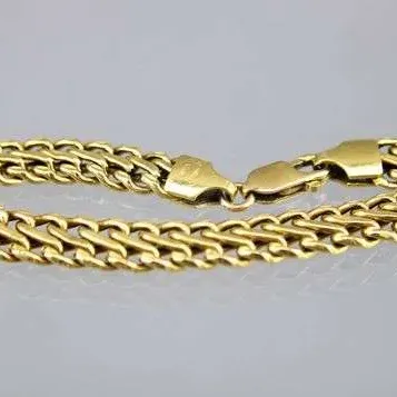 Gold-tone double curb chain bracelet with a lobster claw clasp.