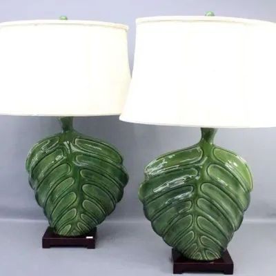 Pair of mid-century modern style green glazed ceramic leaf table lamps, featuring sculpted palm or monstera leaves on dark wooden bases...