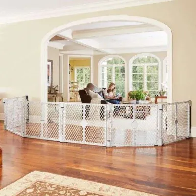 Large multi-panel light gray plastic safety gate set up in a living room arched doorway.