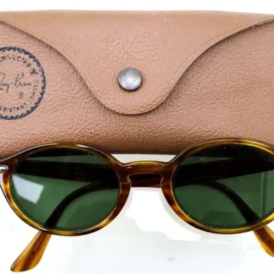 Vintage Bausch & Lomb Ray-Ban tortoise shell oval sunglasses displayed with original tan leather snap case.