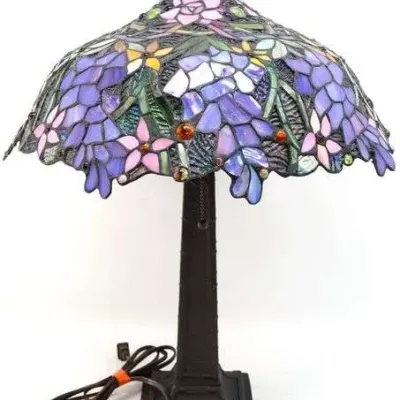 Tiffany-style leaded slag glass table lamp featuring a floral wisteria design in shades of purple and pink on a dark bronze-finished...