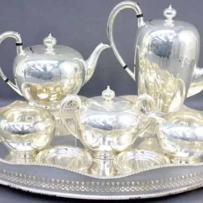 Vintage polished silver-plated coffee and tea service on an ornate pierced tray, including teapot, coffee pot, covered sugar bowl, cream...