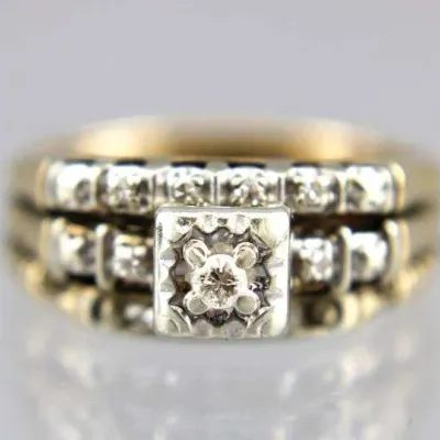 Vintage gold and diamond bridal ring set, featuring a square illusion-setting center stone with channel-set diamond accents.