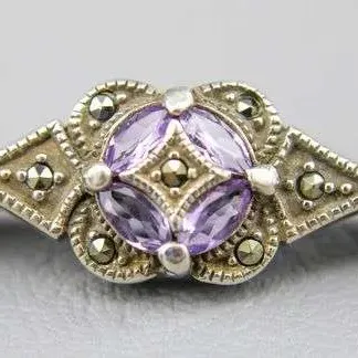 Vintage sterling silver bar pin featuring a central cluster of marquise-cut amethyst stones surrounded by marcasite accents.