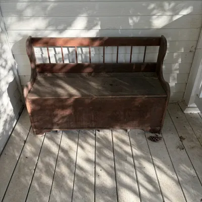Sale Photo Thumbnail #108: Rustic wooden deacon's bench featuring a spindle back, high sides, and a storage trunk base.