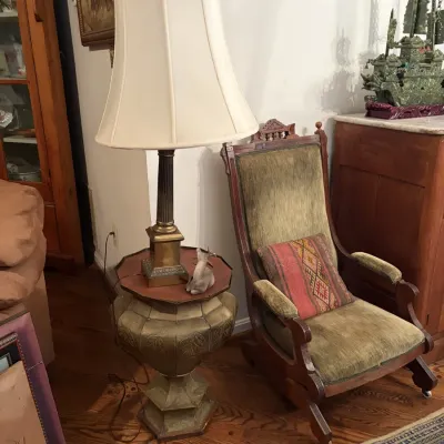 Sale Photo Thumbnail #54: Vintage platform rocking chair with green velvet upholstery alongside a brass-finished pedestal end table and tall brass table lamp.