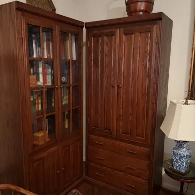 Sale Photo Thumbnail #46: Two dark stain oak storage cabinets, including a glass-door bookcase filled with books and an armoire with lower drawers.