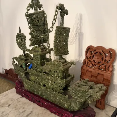 Sale Photo Thumbnail #42: Intricately carved Chinese green jadeite or hardstone dragon boat sculpture with delicate chain links and sails, mounted on a fitted wooden display base.