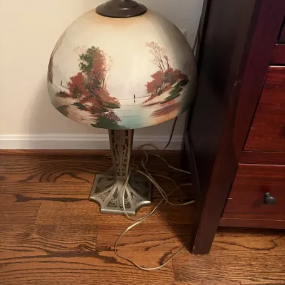 Sale Photo Thumbnail #95: Antique reverse-painted glass dome table lamp depicting a hand-painted autumn landscape over an ornate metal base.