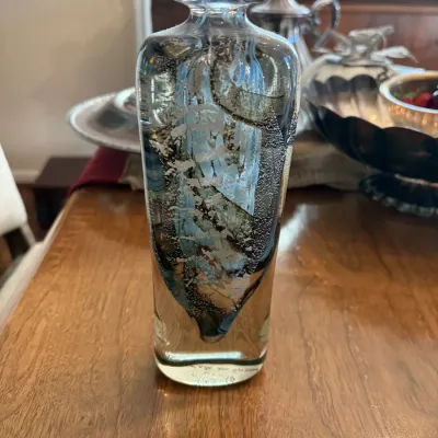 Sale Photo Thumbnail #117: Heavy blown art glass bottle vase featuring swirl details with blue, silver foil, and controlled bubbles embedded in clear glass.