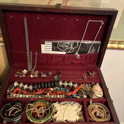 Sale Photo Thumbnail #81: Open wooden jewelry box filled with various costume and fine jewelry, including necklaces, bangles, rings, and a cameo brooch.