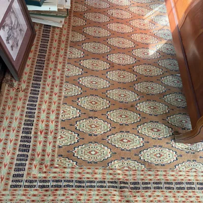 Sale Photo Thumbnail #57: Large Persian or Caucasian style area rug featuring repeating medallion motifs on a terracotta field with a detailed geometric border.