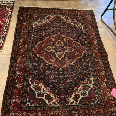 Sale Photo Thumbnail #113: Hand-knotted Persian-style area rug featuring a central floral medallion in deep red, navy blue, and cream tones.