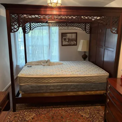 Sale Photo Thumbnail #129: Traditional mahogany canopy bed frame with decorative lattice frieze trim and a panelled headboard.