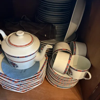 Sale Photo Thumbnail #25: Vintage Imari-style porcelain dinnerware set stored in a wooden cabinet, including a teapot, teacups, saucers, and various stacks of plates.