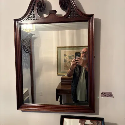 Sale Photo Thumbnail #76: Chippendale-style mahogany wall mirror featuring a broken-pediment top with carved scroll details and fretwork accents.