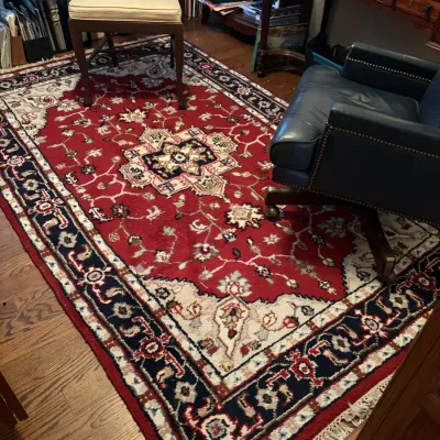 Sale Photo Thumbnail #72: Traditional red and navy Persian-style area rug with a central medallion and fringe border, set in a home office.