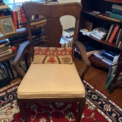 Sale Photo Thumbnail #73: Antique wooden armchair with a shaped splat back, upholstered beige seat cushion, and a small patterned lumbar pillow.