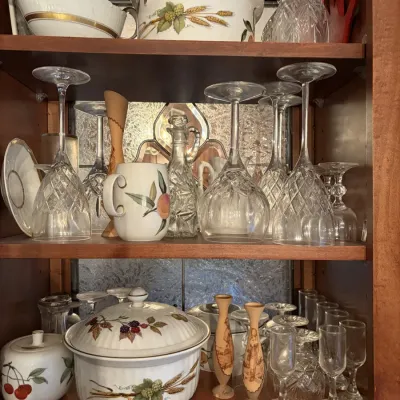 Sale Photo Thumbnail #39: Collection of vintage china and cut crystal stemware arranged inside a wooden cabinet, including covered casseroles with botanical motifs.