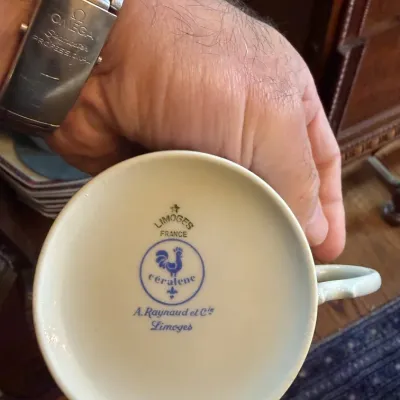 Sale Photo Thumbnail #26: Underside of a Céralene A. Raynaud et Cie Limoges porcelain cup showing the manufacturer's mark with a blue rooster logo.