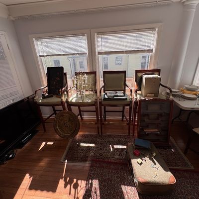 Sale Photo Thumbnail #37: Sunroom displaying four traditional upholstered barstools, oriental rugs, vintage home decor, a small display cabinet, and a flat-screen television.