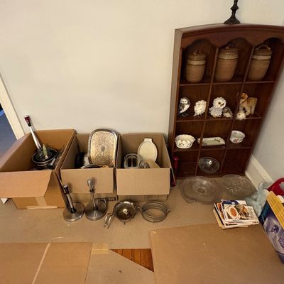 Sale Photo Thumbnail #41: Wooden curio shelf holding small owl figurines and pottery, alongside cardboard boxes packed with various kitchenware, trays, and small appliances.