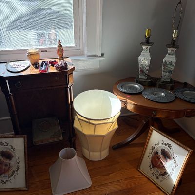 Sale Photo Thumbnail #11: Collection of home decor items including pair of Asian-style porcelain lamps, small wooden accent tables, fabric lampshades, metal decorative plates, and framed photo prints.