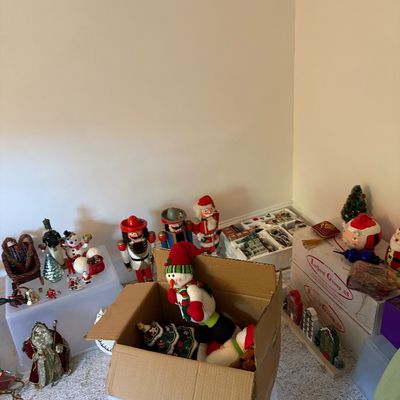 Sale Photo Thumbnail #13: Collection of Christmas decor including wooden nutcrackers, plush snowmen, small festive figurines, and boxed holiday items.