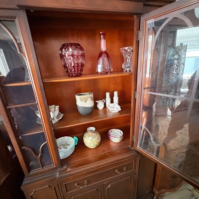 Sale Photo Thumbnail #28: Traditional mahogany china cabinet with glass-front display shelves containing various art glass pieces and ceramics.