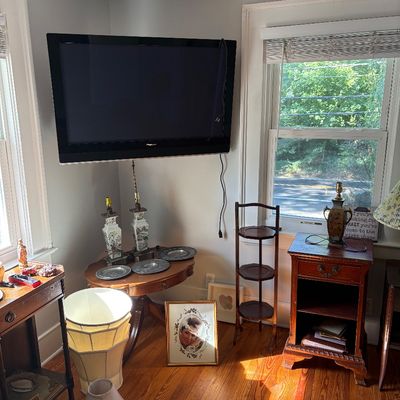 Sale Photo Thumbnail #9: A wall-mounted Pioneer flat-screen TV along with various home furnishings including wooden side tables, table lamps, framed artwork, and decorative pewter plates.
