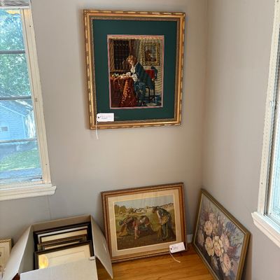 Sale Photo Thumbnail #5: Framed needlepoint artwork hanging on a wall alongside additional framed art pieces resting on the floor and in a box.