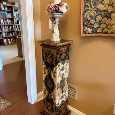 Ornately hand-painted floral display pedestal in a classic Venetian or baroque style, topped with a cherub figural candlestick holder.