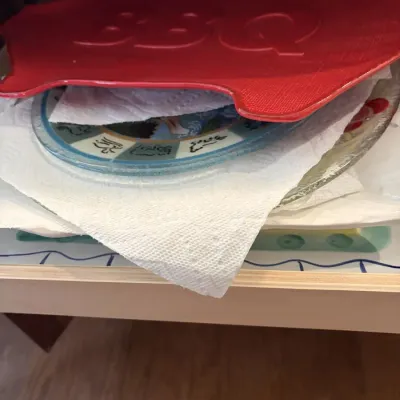 Stack of decorative serving platters, featuring a red pig-shaped BBQ platter on top separated by paper towels.