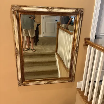 Large rectangular wall mirror featuring an ornate gilt frame with ivory crackle inlay and corner flourishes.