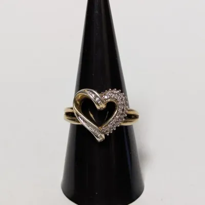 Yellow gold heart ring featuring a cluster of round and baguette accent stones on a split shank band.