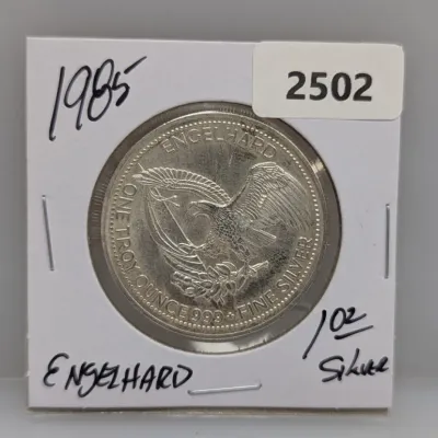1985 Engelhard 1 troy ounce .999 fine silver round featuring an American eagle design, housed in a cardboard flip holder.