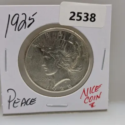1925 Peace silver dollar coin in a protective cardboard flip holder.